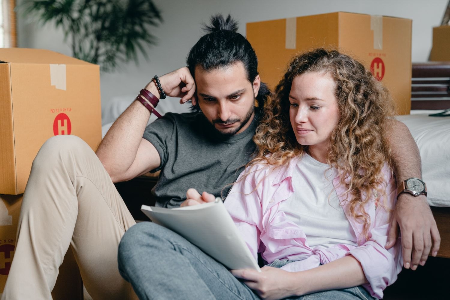 A couple planning with a notebook among moving boxes