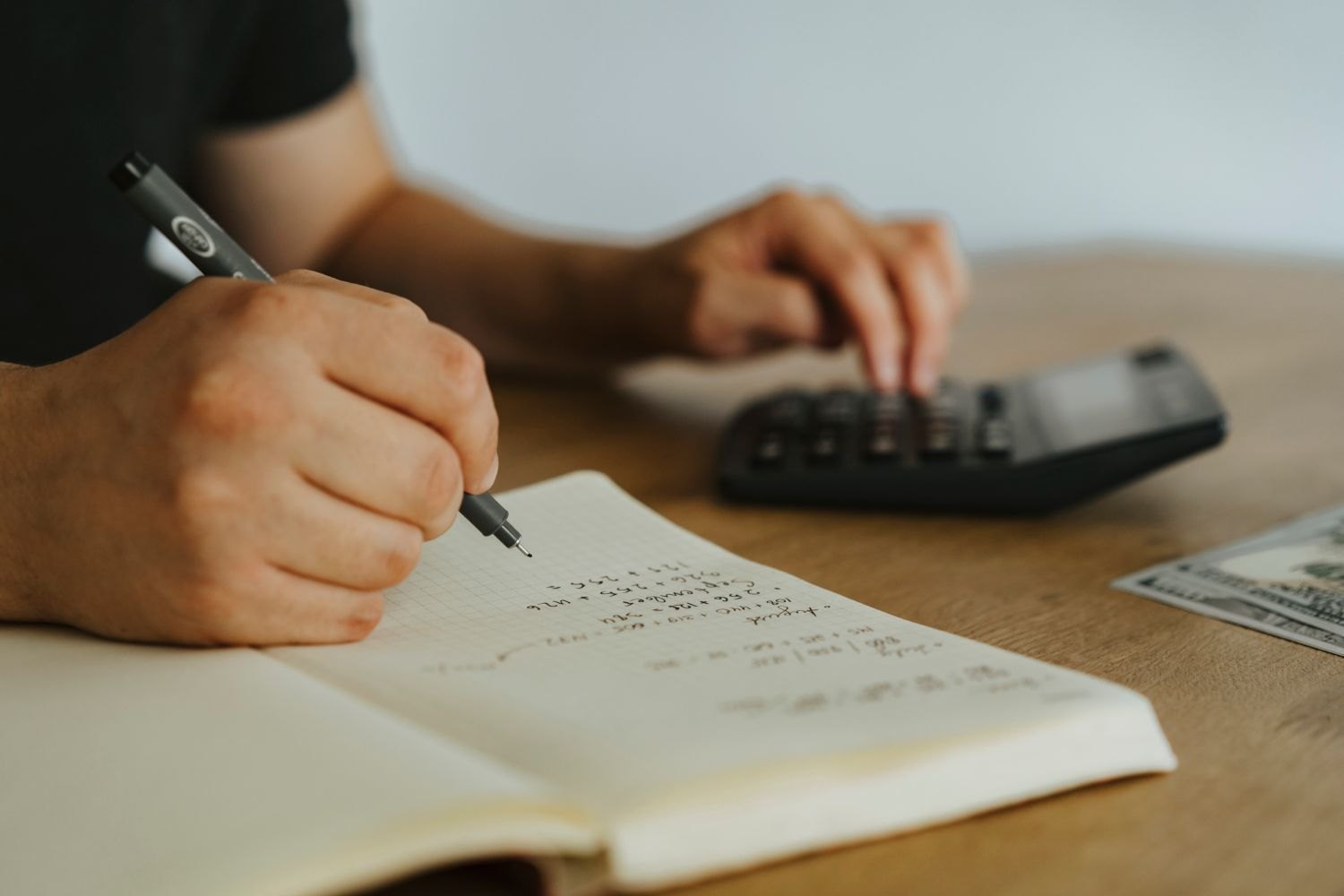 Handwritten calculations beside a calculator
