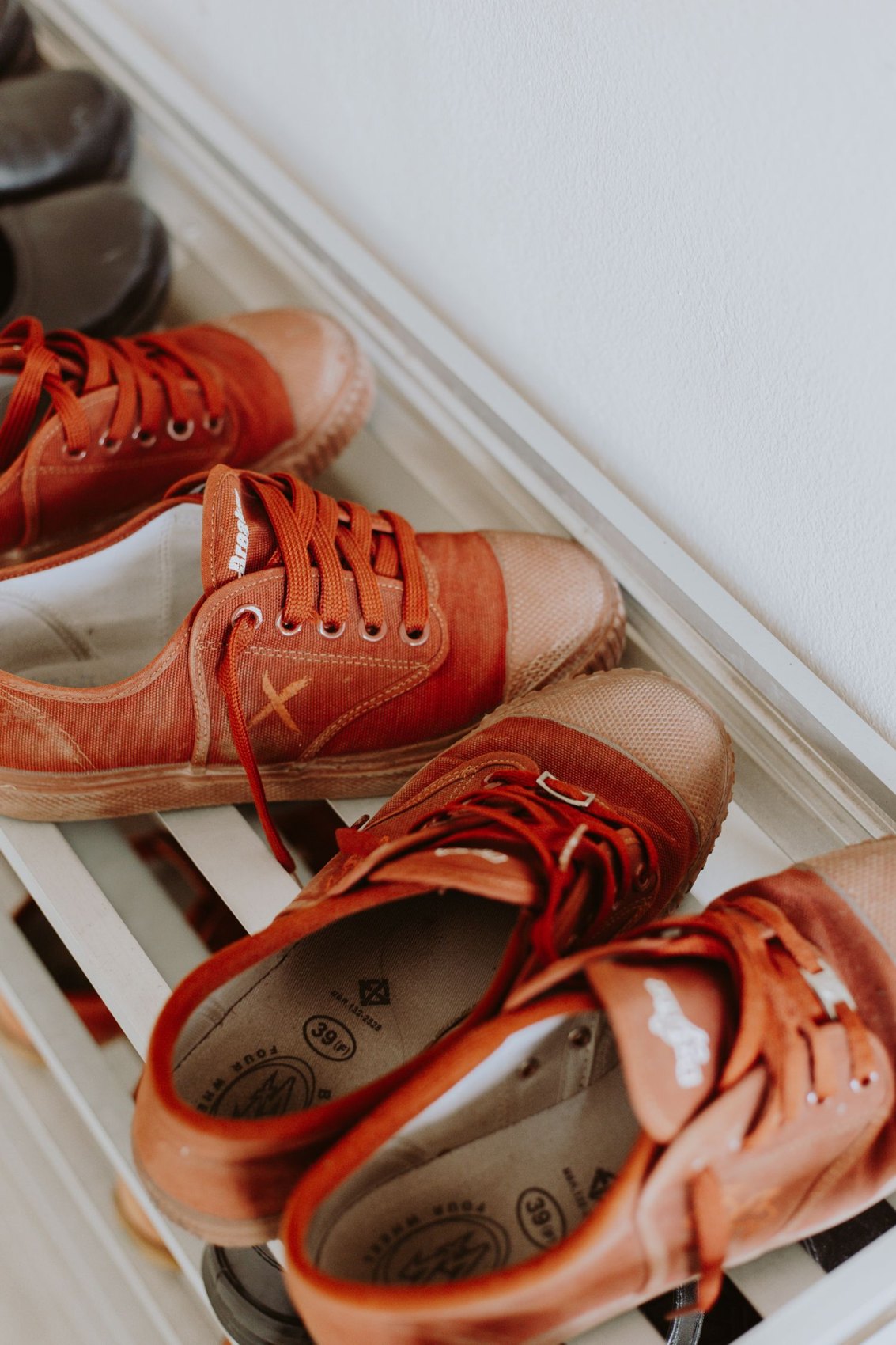 Saubere Schuhpaare auf einem weißen Schuhregal
