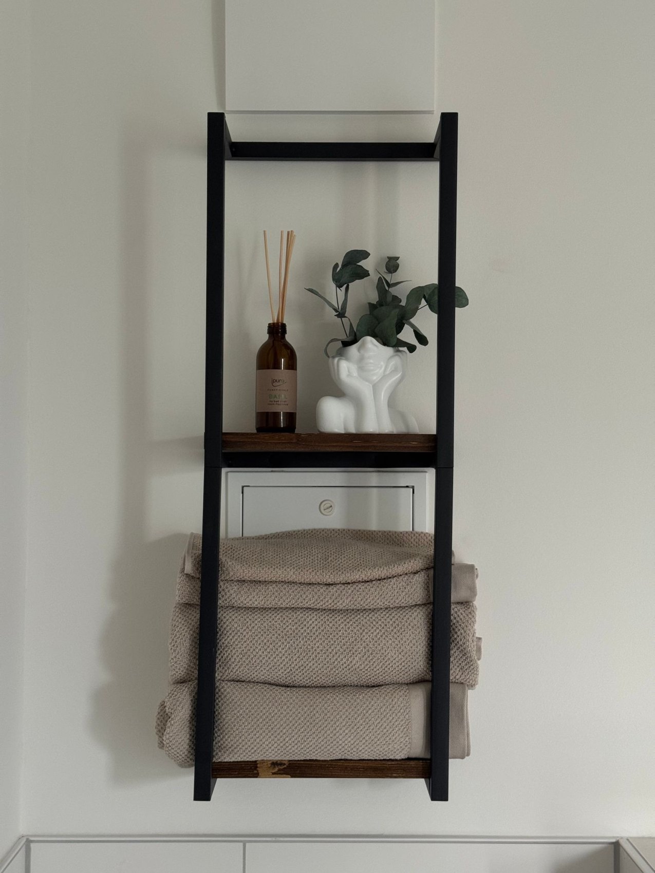Towels and toiletries on a narrow bathroom shelf