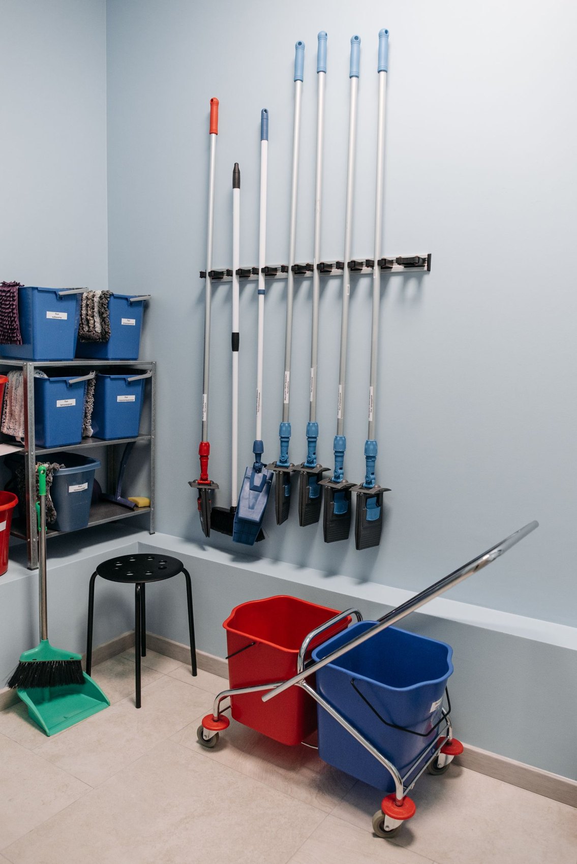 Mops, buckets and cleaning equipment in a utility cupboard