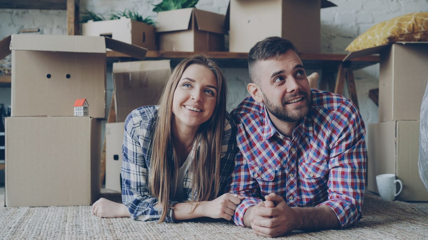 Ein Paar ruht vor gepackten Kartons im neuen Zuhause
